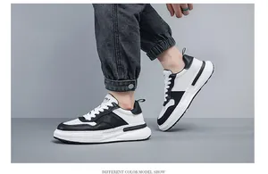 Vista laterale di sneaker panda da uomo in pelle bianca e nera con jeans in denim.