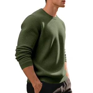 Detailed macro view of the olive green waffle-knit texture on a men's casual crewneck sweater.