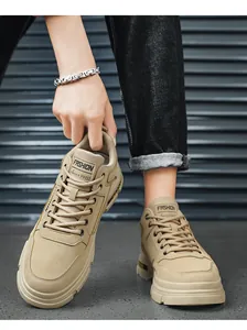 Primer plano de botas de trabajo bajas color caqui con etiqueta "FASHION" y cordones fuertes.