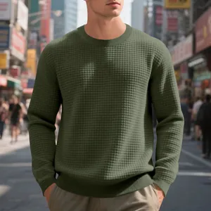 Detailed view of men's olive green waffle knit sweatshirt in urban street setting