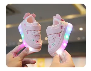 Gros plan de chaussures LED roses pour bébé avec motifs d'ours et semelles souples.
