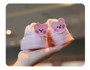 Gros plan détaillé de chaussures de marche roses pour bébé avec oreilles d'ours et semelles LED