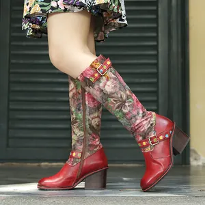 Détail de bottes mi-mollet en cuir rouge avec imprimé fleuri vintage et talon bloc