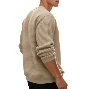 Macro detail showing the texture of men's beige waffle knit crewneck sweatshirt from side view