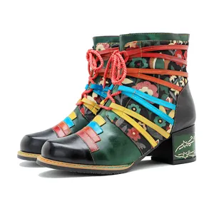 Nahaufnahme bunter Bohemian-Lederstiefeletten mit Blumendruck und farbigen Schnürsenkeln