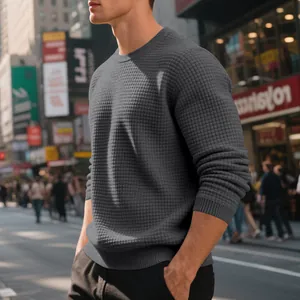 Detailed texture of men's charcoal grey waffle knit crew neck sweater in urban setting