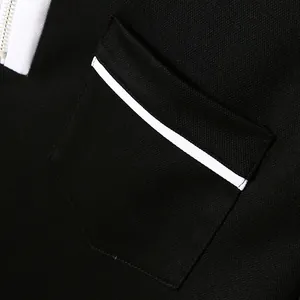 Close-up of piqué fabric texture and chest pocket on a black men's polo shirt