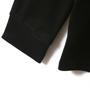 Close-up of black polo shirt sleeve and hem showing detailed knit texture
