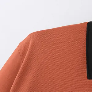 Close-up of orange polo shirt shoulder showing honeycomb textured knit fabric detail