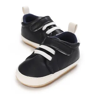 Detailed close-up view of black baby boy sneakers with white laces and velcro strap