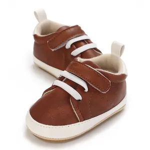 Detailed view of brown faux leather baby sneakers with Velcro strap and white laces