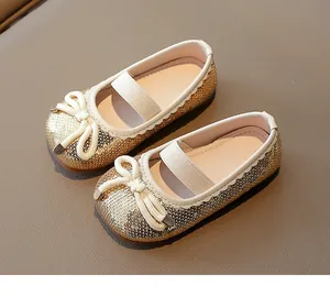 Detailed top view of shimmering gold sequined girls' princess shoes with bow