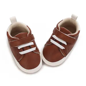Top-down detail of brown baby sneakers with white velcro straps for 0-1 year olds