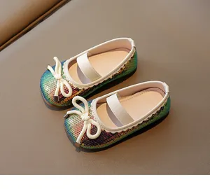 Detail view of sparkling rainbow sequin girls' shoes with cute white bow accent