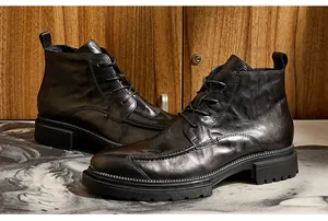 Nahaufnahme schwarzer Herren-Schnürstiefel aus Leder mit Reißverschluss und dicker Sohle