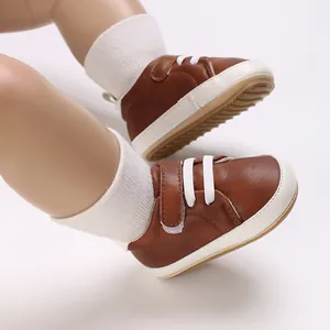 Close-up of brown infant sneakers with soft white soles and laces for baby boys
