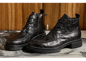 Nahaufnahme von schwarzen Leder-Stiefeletten mit Reißverschluss und dicker Sohle