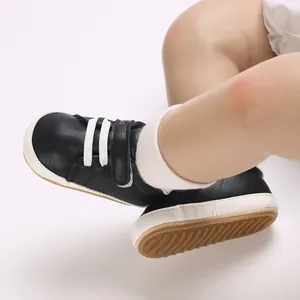 Detailed view of black baby boy casual sneakers with white non-slip rubber soles