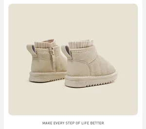 Close-up of beige quilted baby snow boots with side zipper and knit collar details