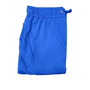 Close-up of folded blue sweatpants showing elastic waistband and drawstring detail.