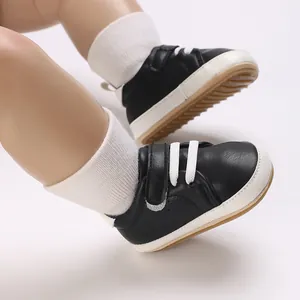 Close-up of stylish black and white baby boy casual sneakers worn on infant feet
