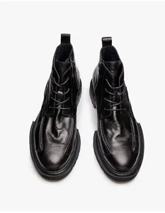 Detailansicht schwarzer Leder-Martin-Boots mit Seitenreißverschluss und dicker Sohle.