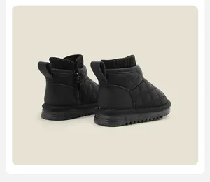 Side view of black quilted kids snow boots with zipper and soft ribbed knit collar.