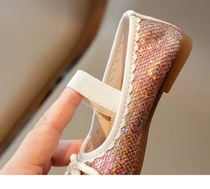 Close-up of sparkling sequins and elastic strap on girls' princess flat shoes.