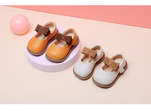 Detailed view of baby girl soft leather princess Mary Jane shoes in orange and beige colors