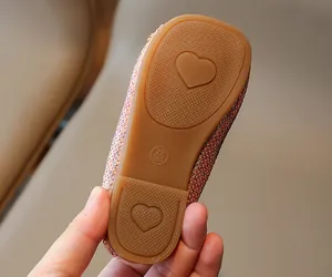 Detail macro view of non-slip rubber sole on rose gold sequin girl's princess shoe