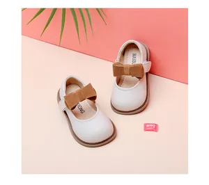 Detail view of cream baby girl princess shoes with decorative brown suede bow