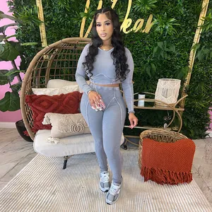 Stylish woman wearing a grey ribbed long-sleeved crop top and high-waisted leggings set