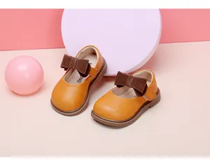 Yellow baby girl princess shoes in soft leather with brown bow detail.