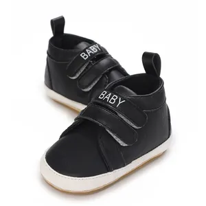 Nahaufnahme von schwarzen Baby-Turnschuhen mit weicher weißer Anti-Rutsch-Sohle und BABY