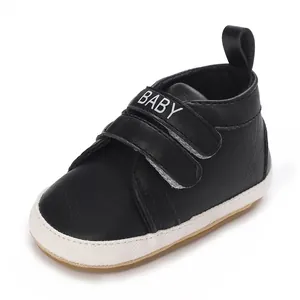 Schwarze Babyschuhe mit weicher weißer Anti-Rutsch-Sohle und BABY Klettverschluss.