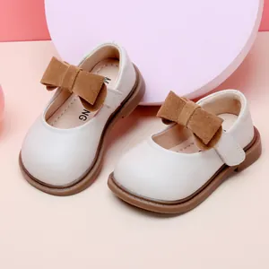 Elegant white baby girl princess shoes featuring a decorative large brown suede bow