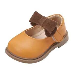 Classic tan baby girl princess shoes made of soft leather with a decorative brown bow