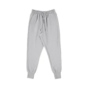 Detail view of grey men's joggers with elastic drawstring waist and cuffed ankles.