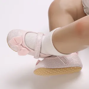 Detailansicht der rosafarbenen, glitzernden Baby-Lauflernschuhe mit Schleife und rutschfester Sohle