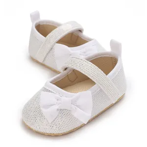 Detail von weißen Glitzer-Babyschuhen für Mädchen mit weicher Sohle und Schleife