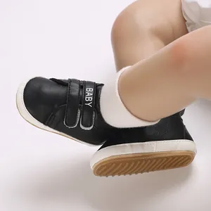 Detailaufnahme der schwarzen Baby-Sneaker mit weichem Klettverschluss und BABY-Logo