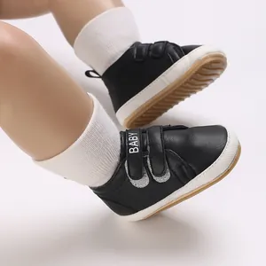 Nahaufnahme schwarzer rutschfester Babyschuhe mit weicher Sohle für Jungen 0-1 Jahr.