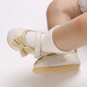 Nahaufnahme von weichen Baby-Lernschuhen für Mädchen mit eleganter Schleife und Glitzer