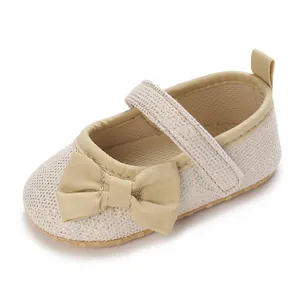 Nahaufnahme von Champagner Glitzer Baby Mädchen Lauflernschuhen mit dekorativer Schleife
