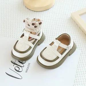 Détail de chaussures Mary Jane pour tout-petit blanches avec bride en T et bordure olive