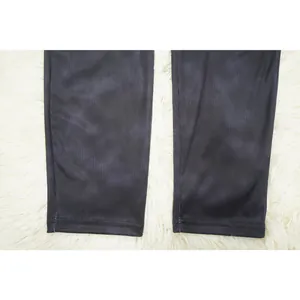 Detail showing black ribbed fabric texture and hem stitching on slim-fit leggings