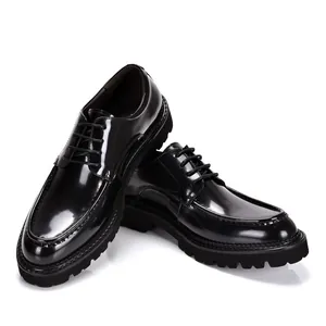 Detail of shiny black patent leather men's derby shoes with thick lugged soles