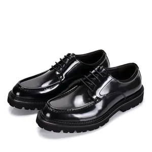 Detailed view of glossy black patent leather shoes with thick lug soles for men's business wear