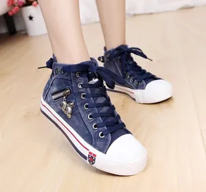 Side view of women's blue denim high-top canvas shoes with unique skull charms