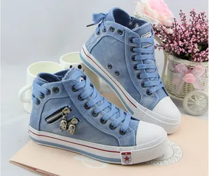 Blue denim high-top canvas sneakers with skull zipper charms and lace-up detail